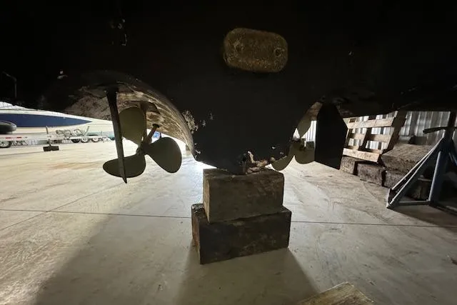 Slide: The Image of 1986 Sea Ray 340 Express Cruiser propellers and rudders in dry dock. - 23