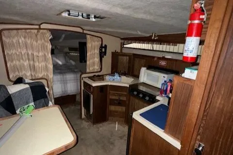 Slide: The Image of Interior of 1986 Sea Ray 340 Express Cruiser with kitchen and sleeping area. - 5