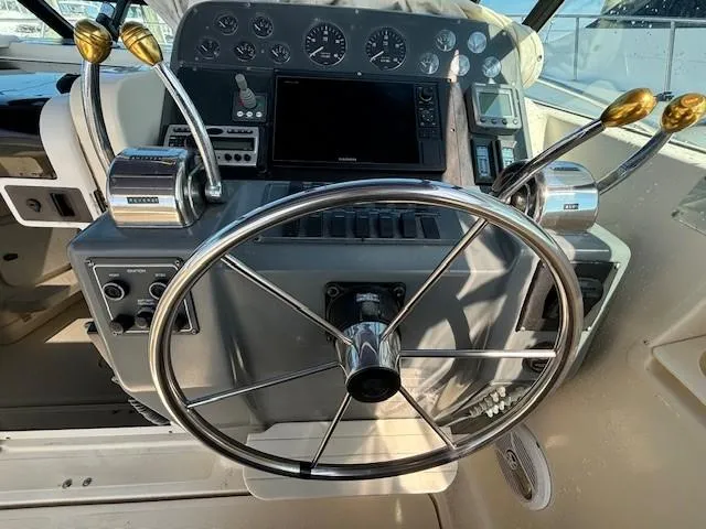 Slide: The Image of 1997 Tiara Yachts 3100 Open helm with steering wheel and control panel. - 12