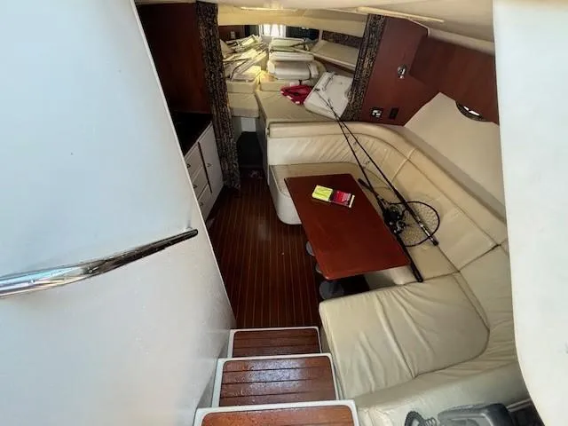 Slide: The Image of 1997 Tiara Yachts 3100 Open interior with seating, table, and fishing rod. - 16