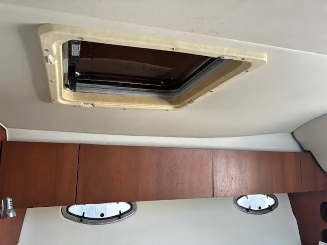 Slide: The Image of Interior cabin of 1997 Tiara Yachts 3100 Open with wooden cabinets and ceiling hatch. - 19