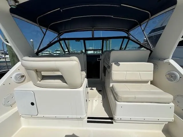 Slide: The Image of 1997 Tiara Yachts 3100 Open interior with white seating and blue canopy. - 5