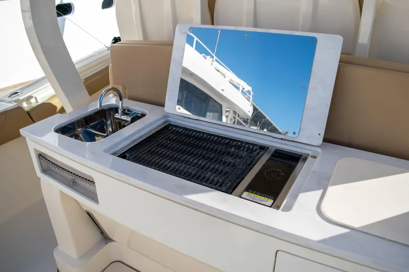 Slide: The Image of Outdoor kitchen on a 2020 Scout 380 LXF boat with sink and grill. - 18