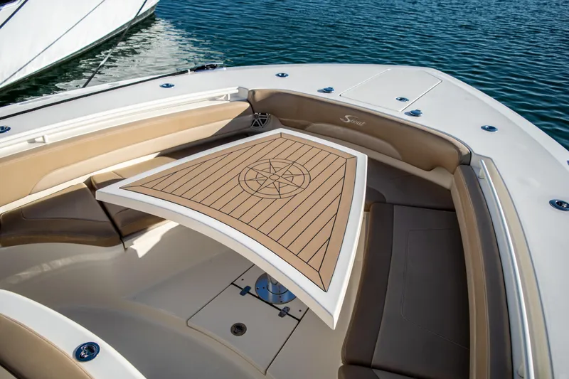 Slide: The Image of 2020 Scout 380 LXF boat with elegant seating and wooden table on calm water. - 32