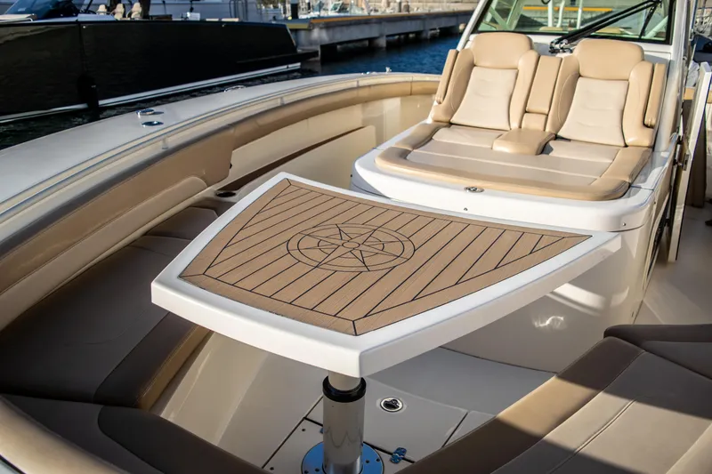 Slide: The Image of 2020 Scout 380 LXF boat interior with luxury seating and wooden table. - 36