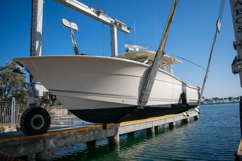 Slide: The Image of 2020 Scout 380 LXF boat being lifted by a crane at a marina. - 4