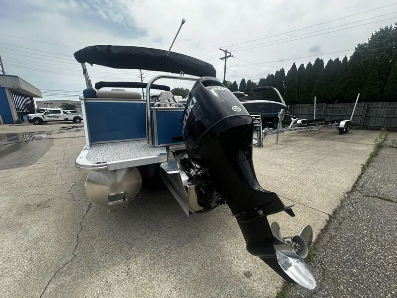 Slide: The Image of 2024 Tahoe CASCADE 2385 QL pontoon boat with Suzuki outboard motor in a parking lot. - 5