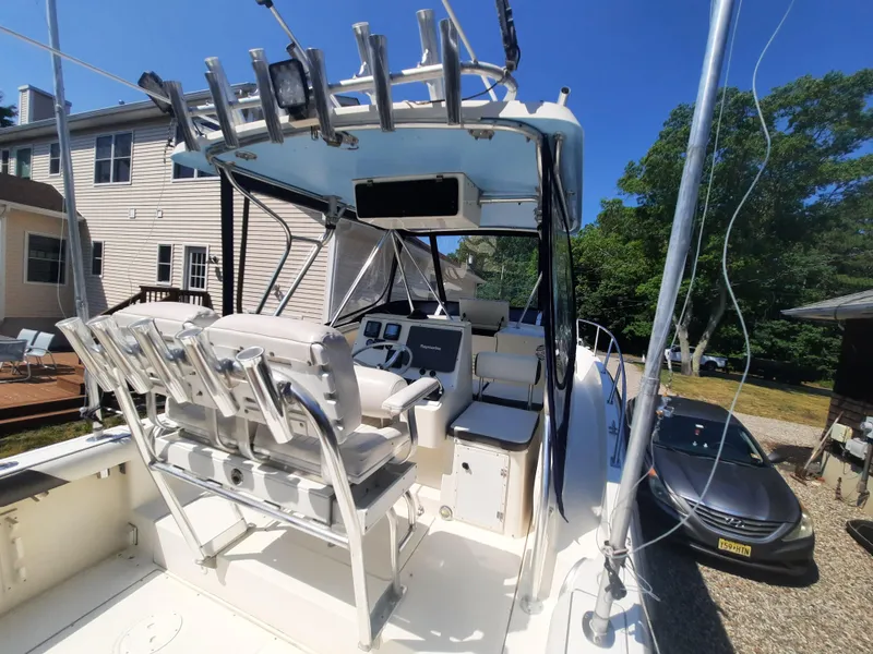 Slide: The Image of 1998 Pursuit 2800 Offshore boat with dual seats and fishing rod holders. - 14