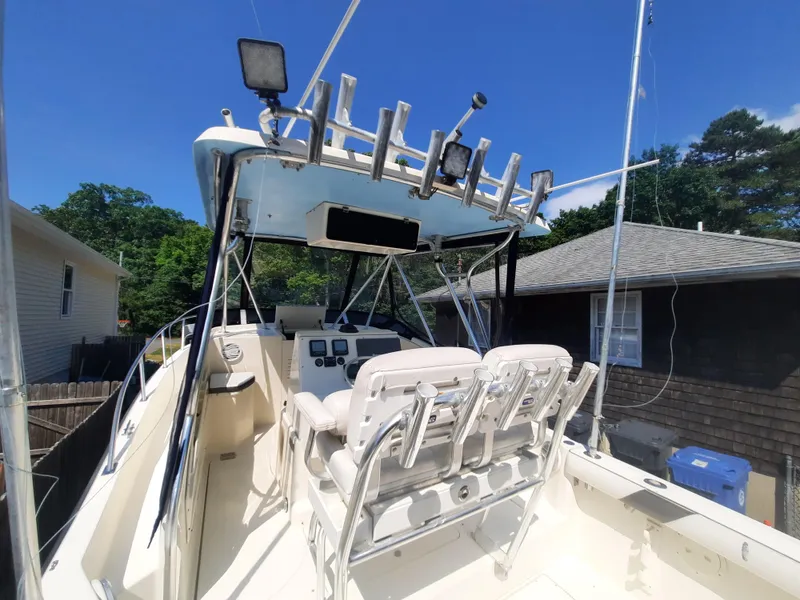 Slide: The Image of 1998 Pursuit 2800 Offshore boat cockpit with seating and fishing rod holders. - 15