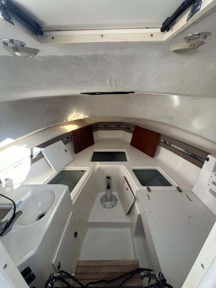 Slide: The Image of 1998 Pursuit 2800 Offshore cabin interior with sink, storage, and seating. - 29