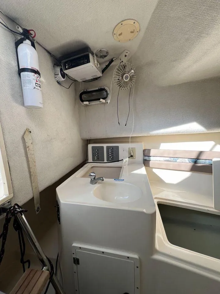 Slide: The Image of 1998 Pursuit 2800 Offshore boat interior with sink and storage. - 30