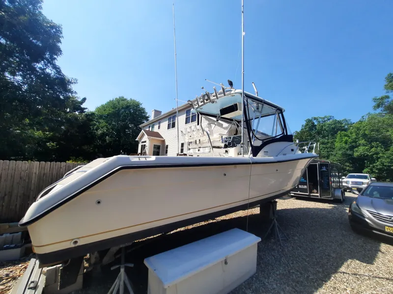 Slide: The Image of 1998 Pursuit 2800 Offshore boat on a trailer in a residential driveway. - 4