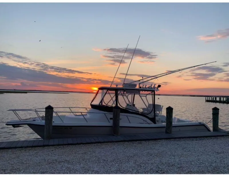 Slide: The Image of 1998 Pursuit 2800 Offshore boat docked at sunset with fishing rods. - 5