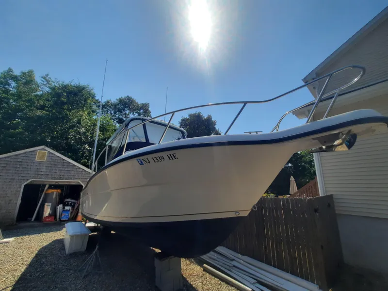 Slide: The Image of 1998 Pursuit 2800 Offshore boat on a trailer in a sunny yard. - 6