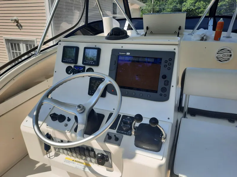 Slide: The Image of 1998 Pursuit 2800 Offshore boat helm with navigation equipment and controls. - 8