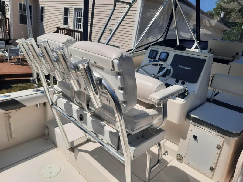 Slide: The Image of 1998 Pursuit 2800 Offshore boat cockpit with seating and fishing rod holders. - 9