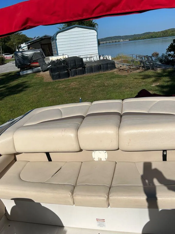 Slide: The Image of 2006 Chaparral 210 SSi boat with beige seating, docked near a lake. - 16