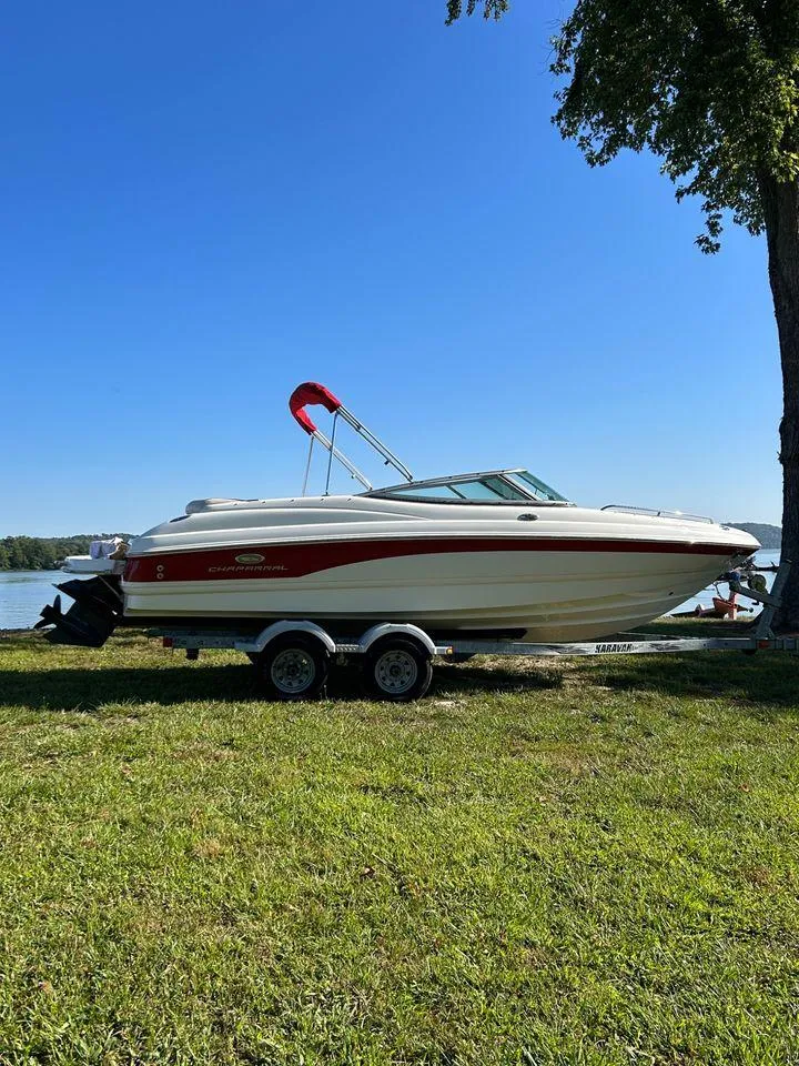 Slide: The Image of 2006 Chaparral 210 SSi boat on a trailer by a lake. - 19