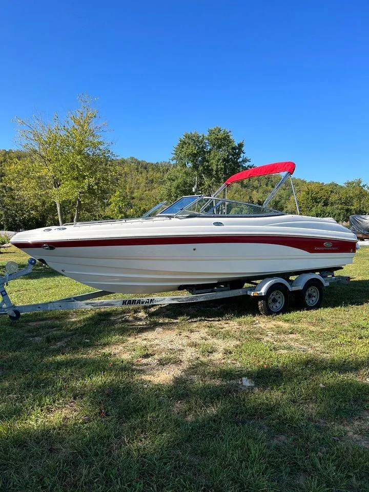 Slide: The Image of 2006 Chaparral 210 SSi boat with red accents on a trailer, parked on grass. - 3