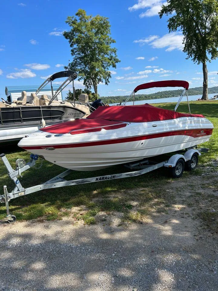 Slide: The Image of 2006 Chaparral 210 SSi boat with red cover on a trailer by a lake. - 5