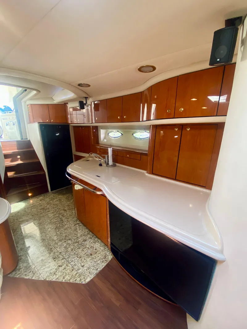 Slide: The Image of 2001 Sea Ray 540 Sundancer yacht kitchen with modern amenities and wooden cabinetry. - 14