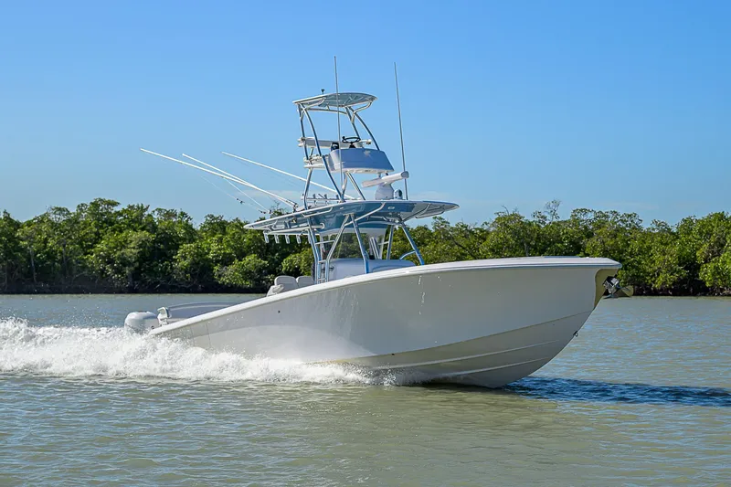 Slide: The Image of 2019 Bahama 41 boat cruising on a sunny day, surrounded by lush greenery. - 10