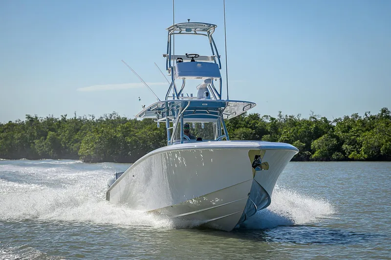 Slide: The Image of 2019 Bahama 41 boat cruising on a sunny day, surrounded by lush greenery. - 11
