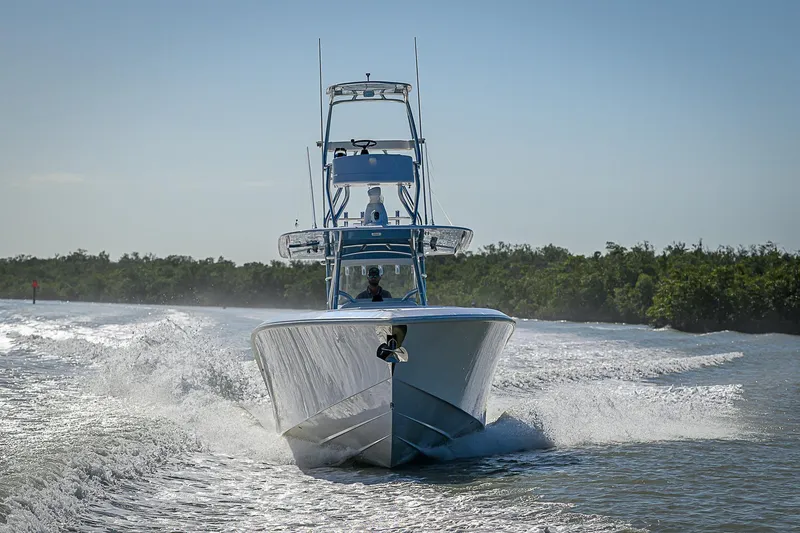 Slide: The Image of 2019 Bahama 41 boat cruising on water, surrounded by lush greenery. - 12