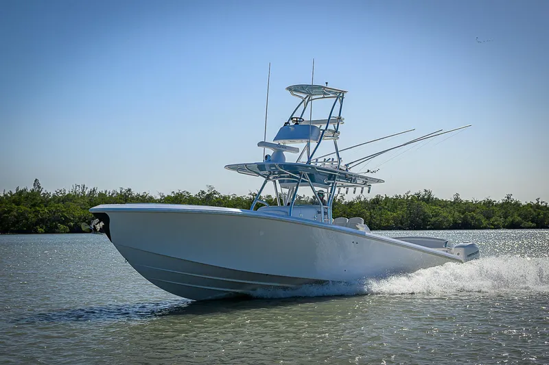 Slide: The Image of 2019 Bahama 41 boat cruising on calm water with lush greenery in the background. - 16