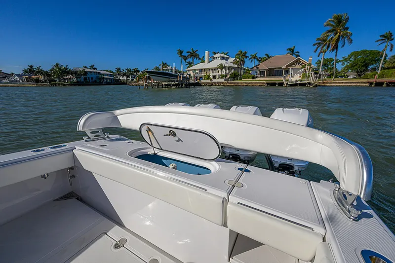 Slide: The Image of 2019 Bahama 41 boat with open deck, scenic waterfront view, and palm trees in the background. - 21