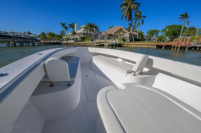Slide: The Image of 2019 Bahama 41 boat with sleek seating, docked near waterfront homes and palm trees. - 23
