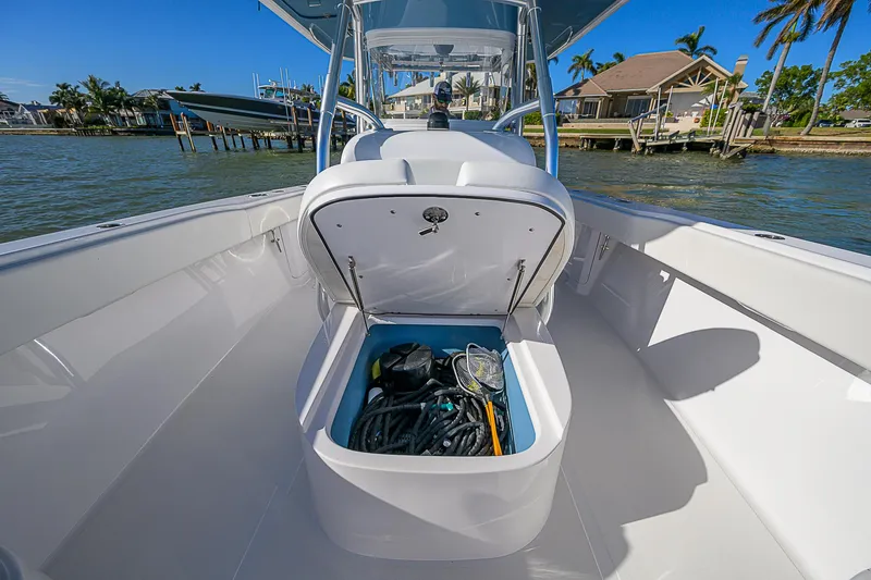 Slide: The Image of 2019 Bahama 41 boat with open storage compartment, docked near waterfront homes. - 26