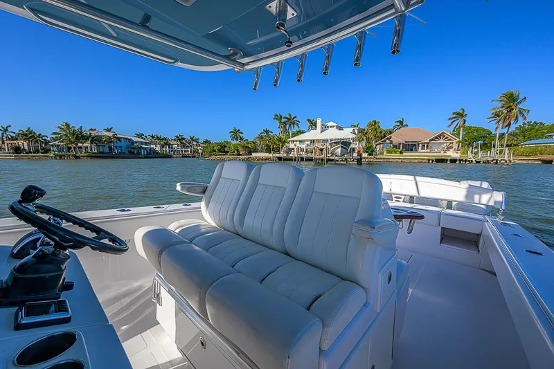 Slide: The Image of 2019 Bahama 41 boat interior with white seating, steering wheel, and waterfront view. - 28