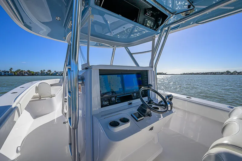 Slide: The Image of 2019 Bahama 41 boat cockpit with navigation screens, steering wheel, and ocean view. - 31