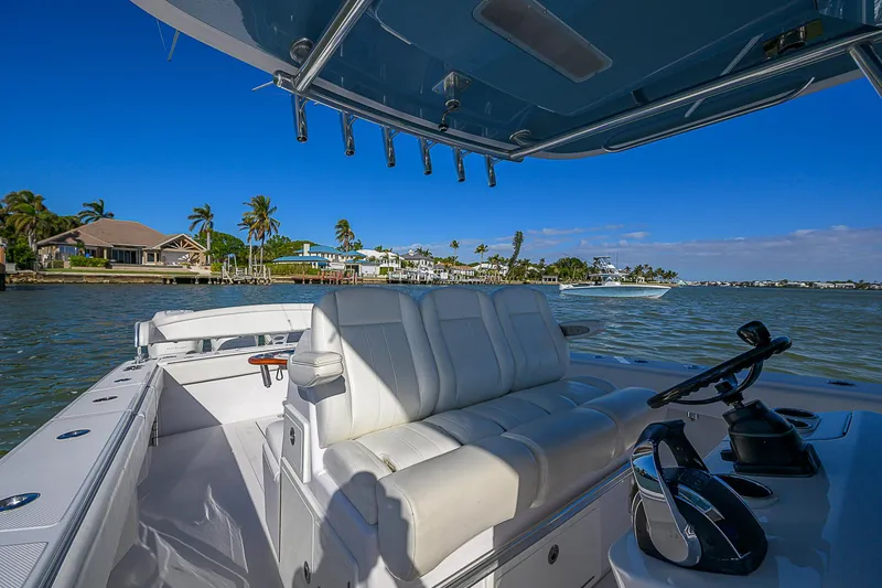 Slide: The Image of 2019 Bahama 41 boat interior with white seating, steering console, and scenic waterfront view. - 32