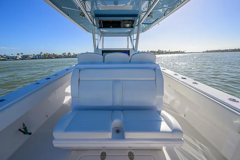Slide: The Image of 2019 Bahama 41 boat interior with white seating, on calm water under clear blue sky. - 38