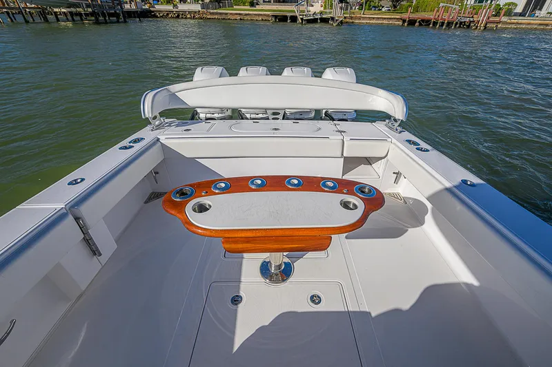 Slide: The Image of 2019 Bahama 41 boat deck with fishing rod holders and seating, on calm water. - 40