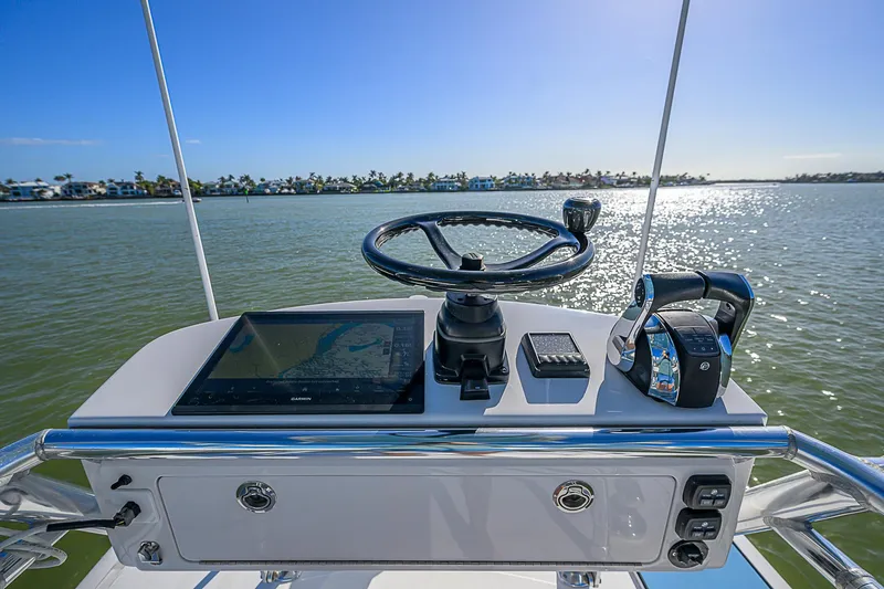 Slide: The Image of Control panel of a 2019 Bahama 41 boat with steering wheel and navigation equipment. - 44