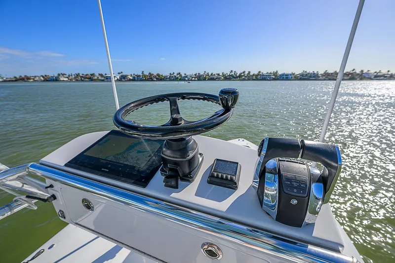 Slide: The Image of Helm of 2019 Bahama 41 boat with steering wheel and controls, overlooking calm waters. - 46