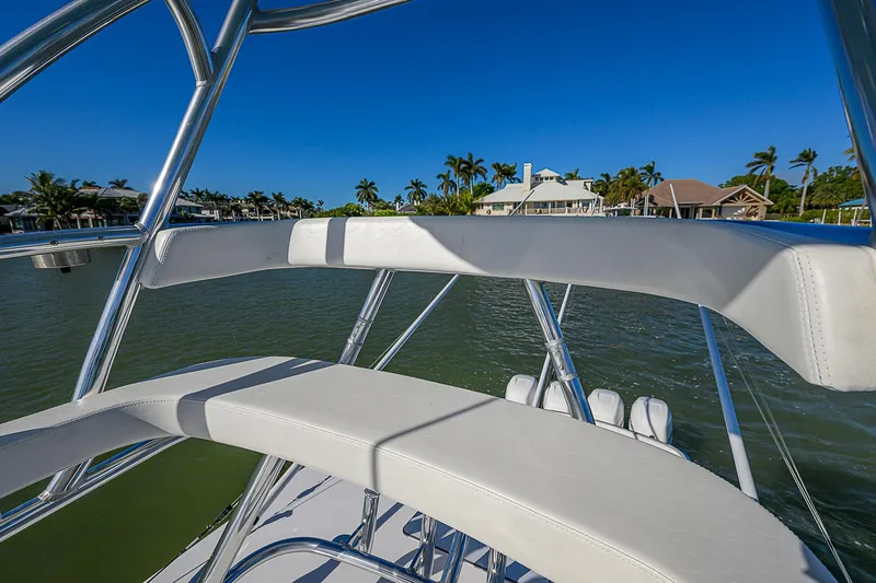 Slide: The Image of 2019 Bahama 41 boat with sleek seating, overlooking waterfront homes and palm trees. - 47