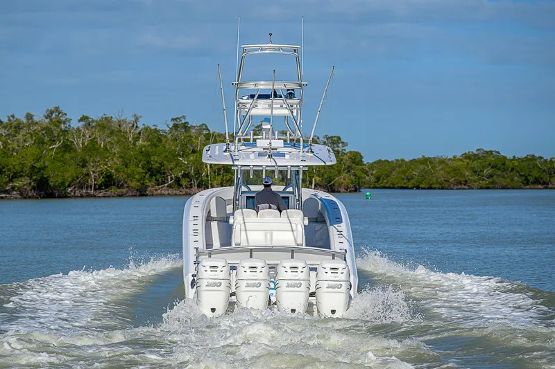 Slide: The Image of 2019 Bahama 41 boat cruising on a calm waterway with lush greenery. - 9
