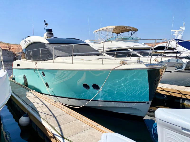 Slide: The Image of 2015 Monte Carlo MC5S yacht docked at marina, turquoise hull, sleek design. - 2