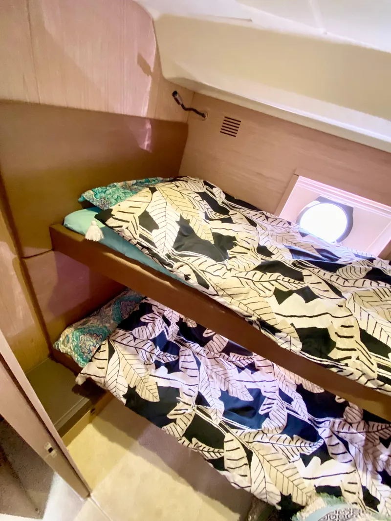 Slide: The Image of Bunk beds in 2015 Monte Carlo MC5S yacht cabin with patterned bedding and porthole window. - 32