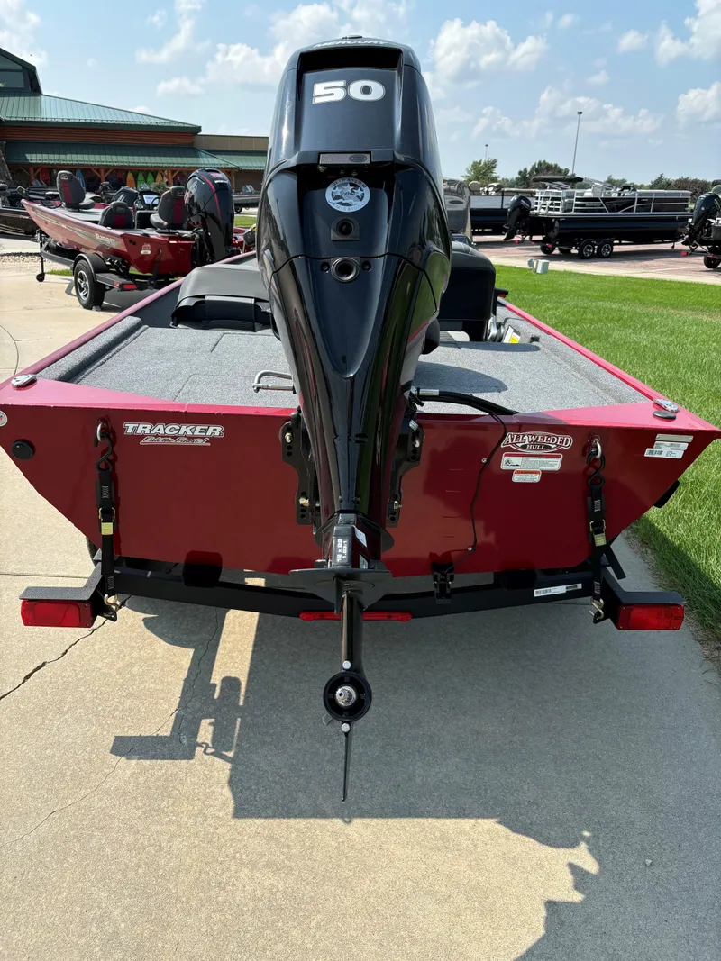 Slide: The Image of 2024 Tracker Bass Tracker Classic XL boat with 50 HP engine, parked outdoors. - 2