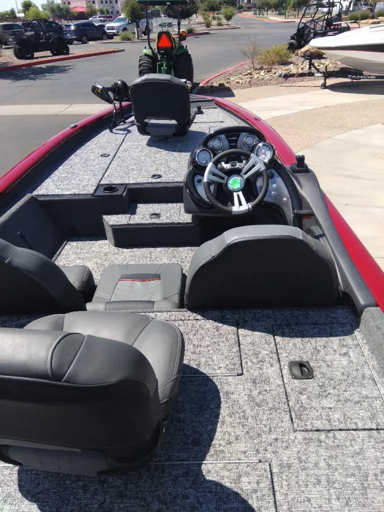 Slide: The Image of 2024 Tracker Pro Team 190 TX fishing boat interior with steering console and seating. - 2