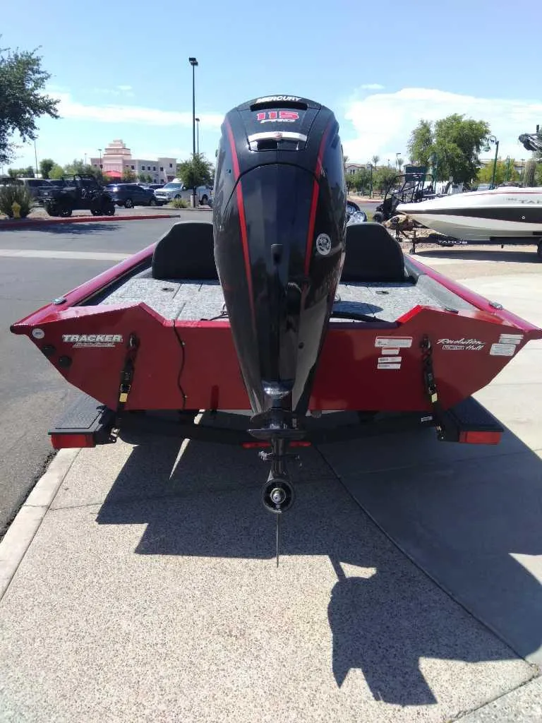 Slide: The Image of 2024 Tracker Pro Team 190 TX boat, red exterior, parked outdoors. - 4
