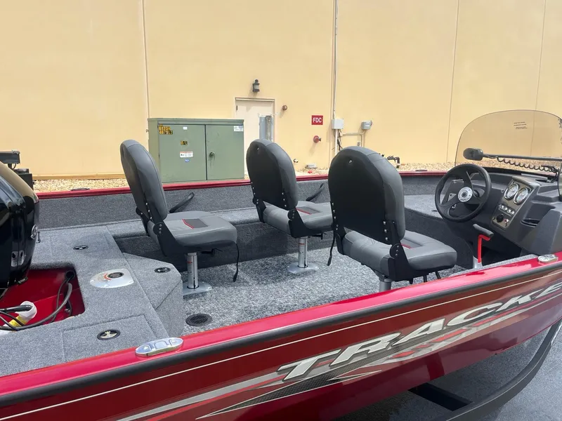 Slide: The Image of 2024 Tracker Pro Guide V-16 SC fishing boat with red exterior and three seats. - 38