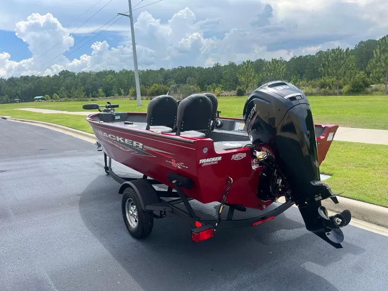Slide: The Image of 2024 Tracker Pro Guide V-16 SC boat on trailer, red exterior, parked outdoors. - 4