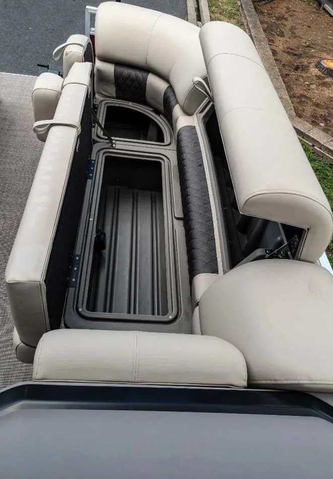 Slide: The Image of 2024 Sun Tracker Party Barge 20 DLX seating with storage compartments open. - 12