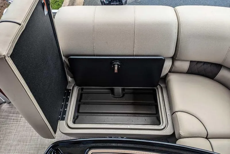 Slide: The Image of Sun Tracker Party Barge 20 DLX 2024 storage compartment with open seat cushion. - 14